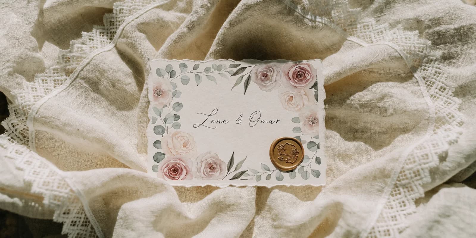 Personalized wedding thank-you card with botanical watercolor border and lettered couple names on cream